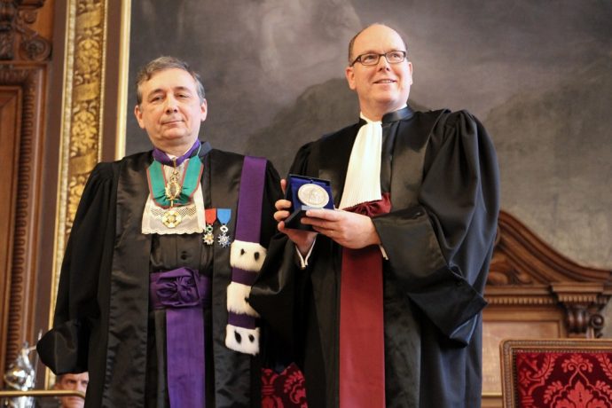 Gilles Pécout (à gauche) et S.A.S. Albert II de Monaco montrant la Grande Médaille de la Chancellerie à l’assemblée lors du DHC du souverain.