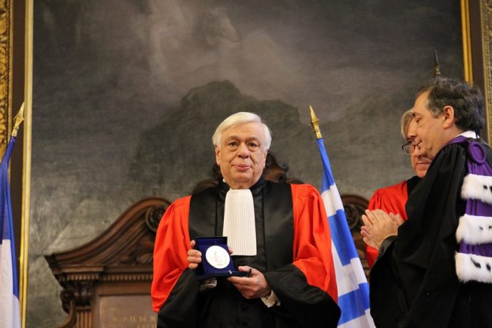 Le Président Prokopis Pavlopoulos montrant la Grande Médaille de la Chancellerie des universités de Paris à l’assemblée.