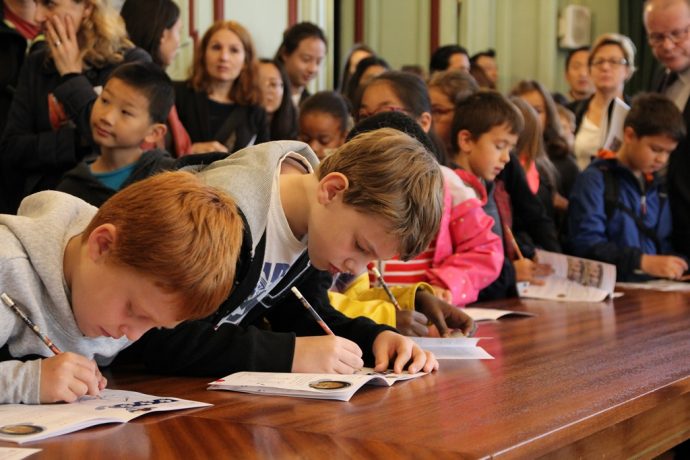 Des enfants complètent le guide jeune public lors des JEP 2017 en Sorbonne.