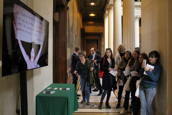 Le public observant l’une des installations vidéos réalisées par les élèves. Dévoilement des sept portraits de femmes illustres faits par l'artiste C215 pour la Sorbonne : "Aux grandes femmes, la Sorbonne reconnaissante".