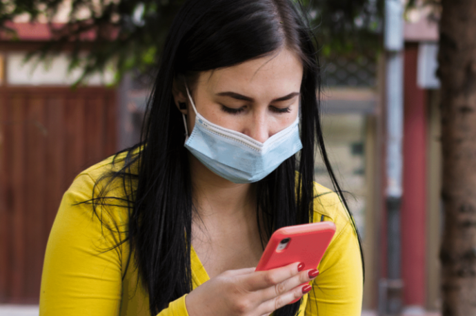 Une étudiante avec un masque chirurgicale consulte son smartphone. Copyright etudiant.gouv.fr